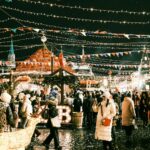 a crowd of people walking around a christmas market