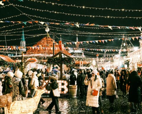a crowd of people walking around a christmas market
