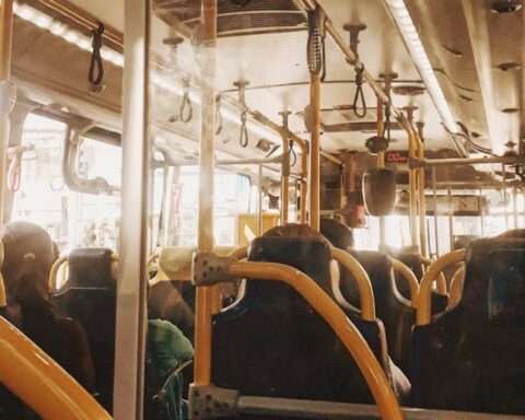 Interior view of a bus with people on a typical public transportation commute.
