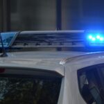 Close-up of a police car's flashing blue lights in an urban environment.