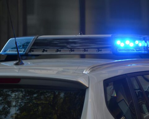 Close-up of a police car's flashing blue lights in an urban environment.