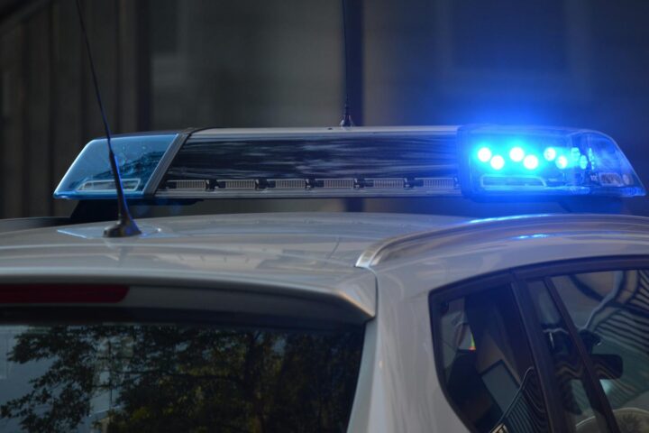 Close-up of a police car's flashing blue lights in an urban environment.