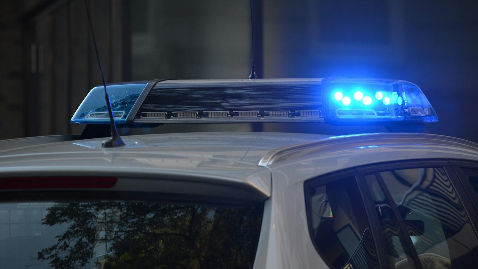Close-up of a police car's flashing blue lights in an urban environment.