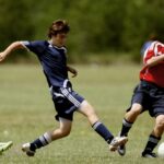 Teenage soccer players in action during an outdoor match showcasing skill and competition.