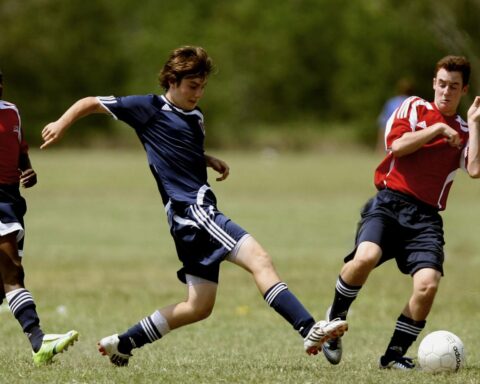 Teenage soccer players in action during an outdoor match showcasing skill and competition.