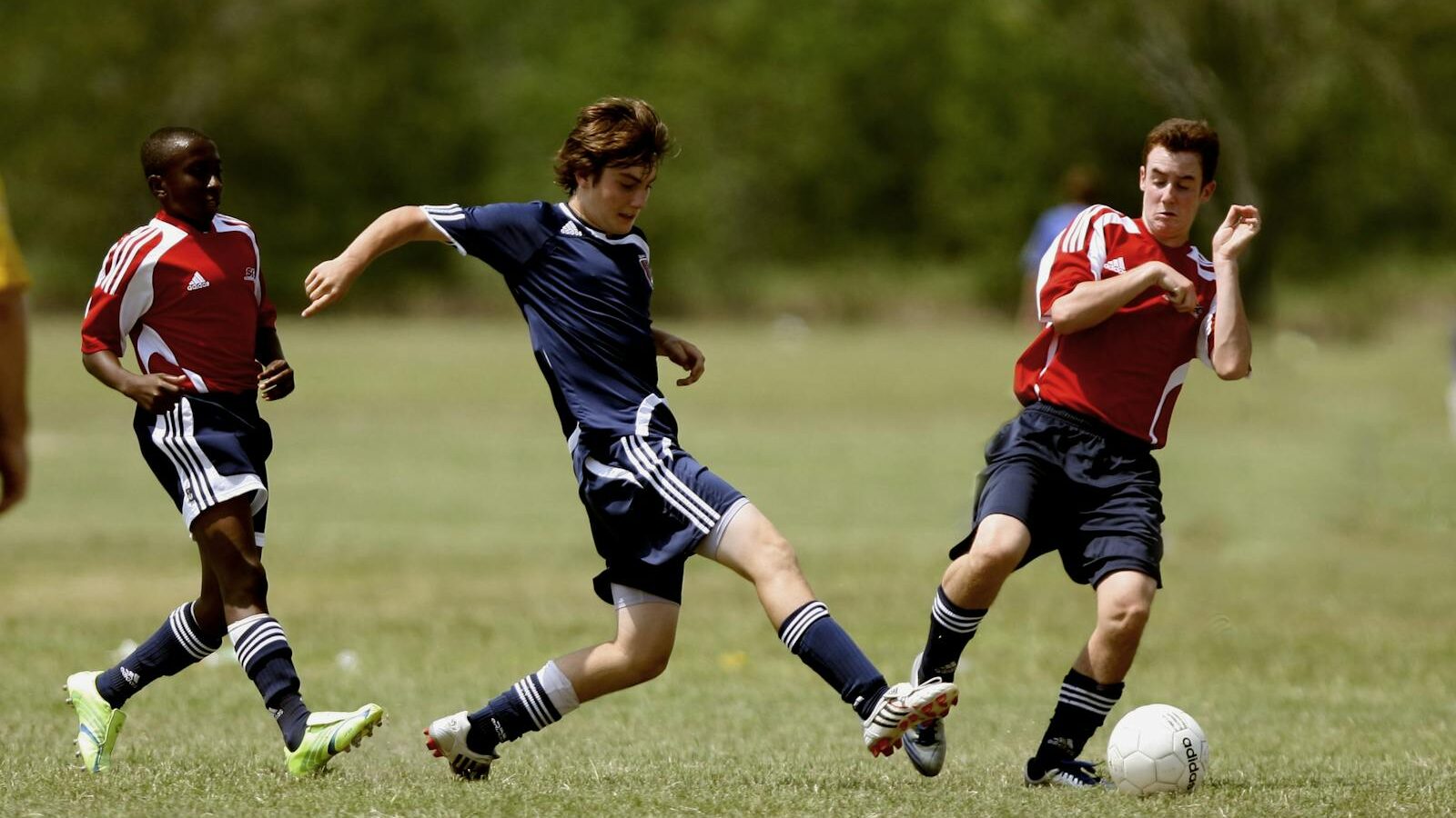 Teenage soccer players in action during an outdoor match showcasing skill and competition.