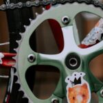 Close-up view of a bicycle crankset featuring colorful animal stickers.