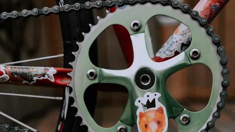 Close-up view of a bicycle crankset featuring colorful animal stickers.