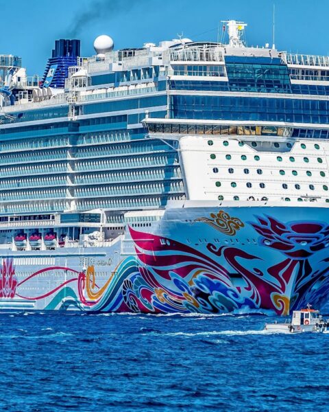 A colorful cruise ship sailing on the open sea under a clear blue sky. Ideal for tourism and travel themes.