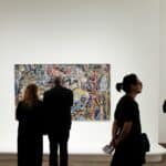 a group of people standing in front of a painting