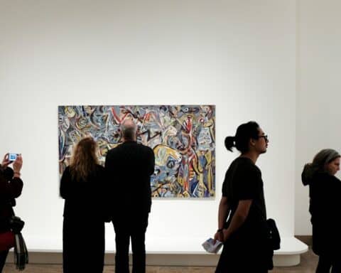 a group of people standing in front of a painting