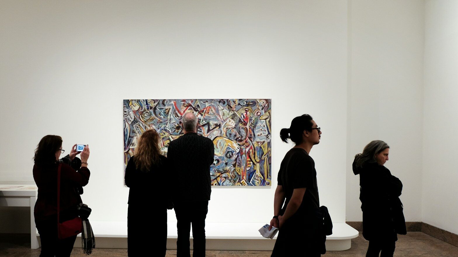 a group of people standing in front of a painting