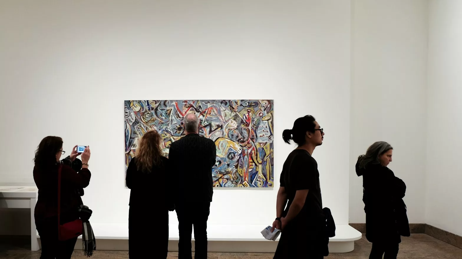a group of people standing in front of a painting