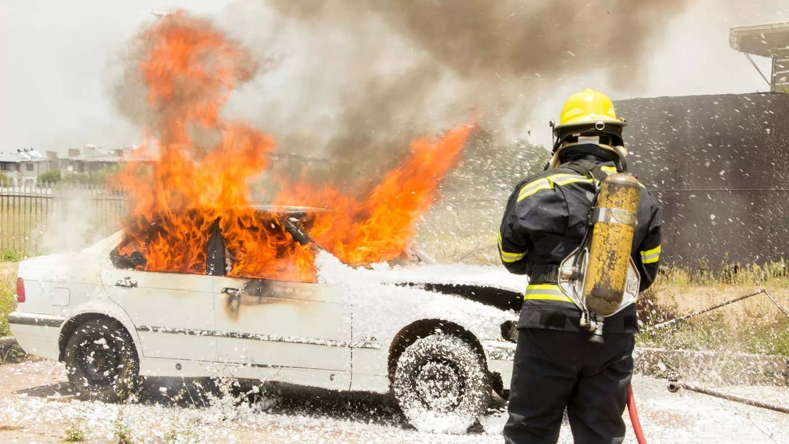 firefighter fighting burning car