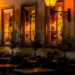 A row of tables sitting outside of a restaurant at night