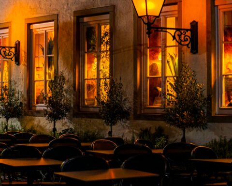 A row of tables sitting outside of a restaurant at night